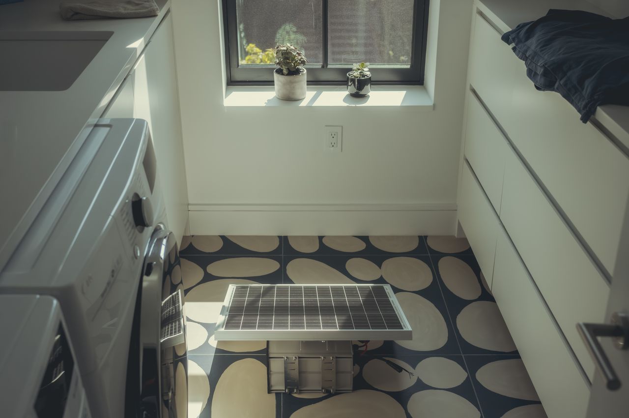 A solar panel being tested on a laundry room floor.